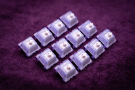 Load image into Gallery viewer, Hera Switches for mechanical keyboards, displayed on purple crushed velvet. Sold by Vala Supply
